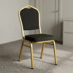 Black stackable conference chair featuring black fabric upholstery patterned with gold polka dots, a padded crown-back backrest and seat, and a durable gold-finished metal frame.