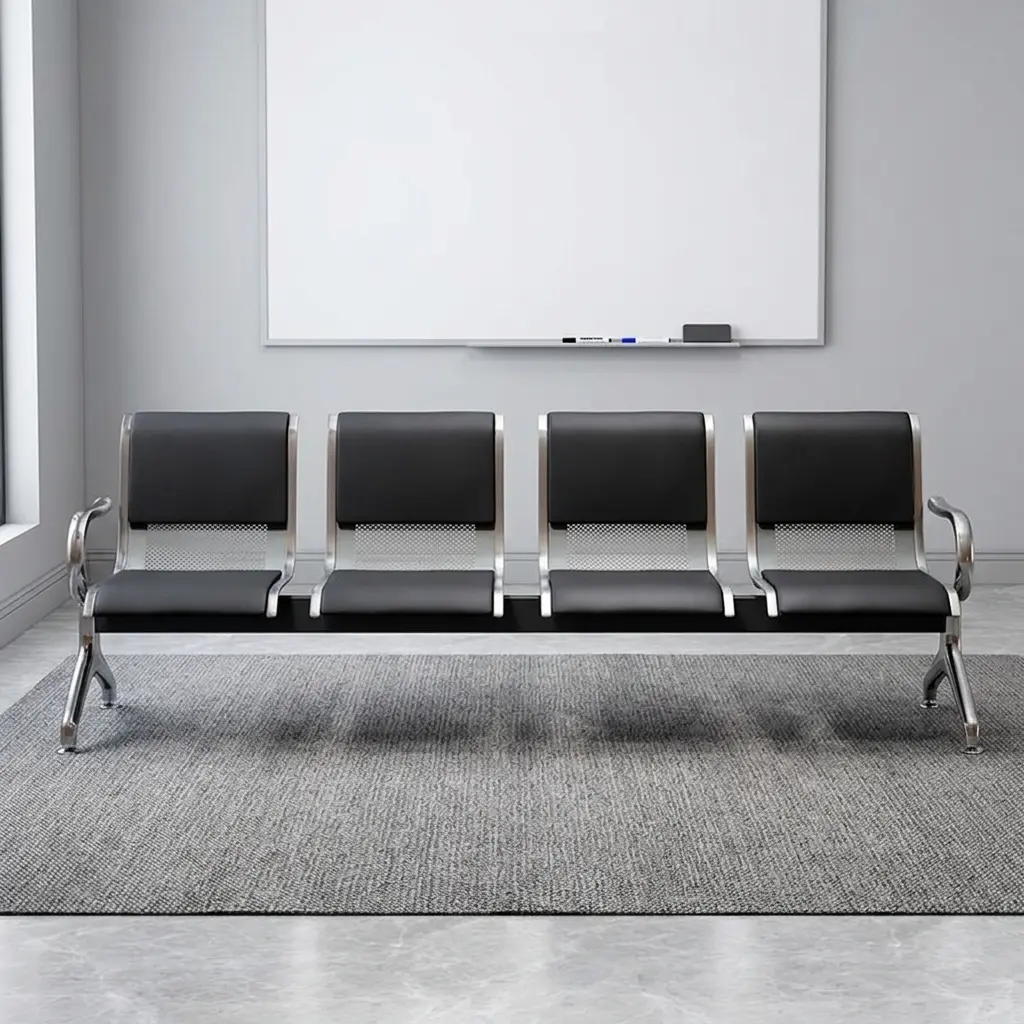 4-seater waiting bench featuring four contoured black leatherette padded seats, silver perforated metal backrest panels, polished chrome side armrests and legs, and a heavy-duty horizontal beam support structure.