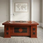 Executive 1800mm office table featuring a classic polished reddish-brown cherry wood finish, a gently curved front desktop with an embedded dark writing pad and cable grommets, decorative modesty paneling with dark inlay accents, and side pedestal bases.