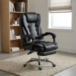 High-back ergonomic leather chair featuring plush black bonded leather upholstery with segmented horizontal padding, an integrated thick headrest, padded loop armrests, a retractable fold-out footrest under a double-padded seat cushion, and a polished chrome five-star base on smooth-rolling dual-wheel casters.