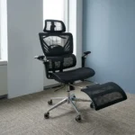 Recliner orthopedic chair with footrest featuring a breathable full-black mesh construction, an adjustable mesh headrest, a multi-segmented high backrest with specialized lower lumbar support, 3D adjustable armrests, a retractable mesh footrest, and a polished metallic five-star base on smooth-rolling casters.