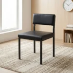 Black stackable catalina chair featuring a minimalist armless steel frame with a black powder-coated finish, a padded black faux leather low-profile backrest, a thick cushioned seat, and straight square legs.