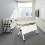 120cm foldable training table featuring a rectangular white laminate tabletop with a black edge band, integrated onto a white metal nesting frame with a matching solid white modesty panel, supported by angled T-legs equipped with dual-wheel locking casters.