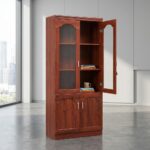 2-door office file cabinet featuring a tall wooden structure with a rich reddish-brown cherry wood grain finish, designed with an upper display section with arched glass-paneled doors enclosing interior storage shelves, and a lower base cupboard with twin solid wood doors, all accented by slim vertical silver handles.