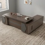 L-shaped 2400mm office table featuring a dark walnut wood-grain desktop with an integrated leatherette writing pad inlay, a modesty panel with a horizontal textured accent stripe, diamond-quilted decorative side pillar panels, and an extended side return cabinet providing multi-functional storage.