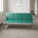 Green 3-seater waiting bench featuring padded emerald green leatherette seat and backrest cushions, a durable light grey rectangular metal frame, integrated side armrests, and sturdy legs with black protective floor caps.