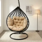 High quality hammock swing featuring a teardrop-shaped dark brown woven wicker egg chair, a thick tufted beige cushion set, and a heavy-duty black metal hanging stand with a circular base.