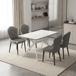 4-seater dining set featuring a rectangular white marble-patterned tabletop with white geometric angled metal legs, paired with four grey leatherette upholstered chairs with button-tufted inner backrests and tapered black legs.