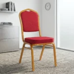Stackable red conference chair featuring a crown-back gold-finished metal frame, padded seat and backrest upholstered in red patterned fabric with gold dot detailing, and four fixed legs with protective floor glides.