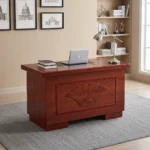 120cm office table with drawers featuring a rich mahogany/cherry wood veneer finish, a central black desk pad inset on the desktop, and a decorative front modesty panel with a carved fan shell motif and textured border molding.