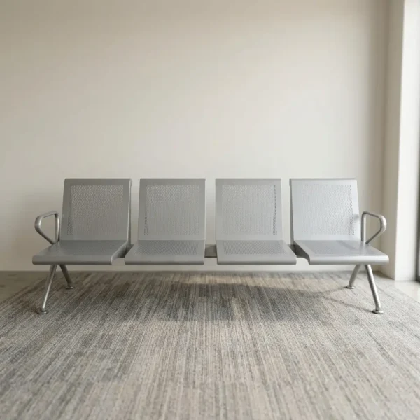 Heavy duty 4-seater waiting bench featuring a durable metallic silver-grey steel construction, four individual perforated metal seats and backrests, curved side armrests, a heavy-duty central support beam, and angled steel legs.
