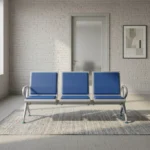 Heavy duty blue waiting bench featuring a 3-seater design with cushioned royal blue leatherette seat and back pads, a silver powder-coated steel frame, integrated side armrests, and a sturdy beam structure supported by slanted legs with leveling glides.