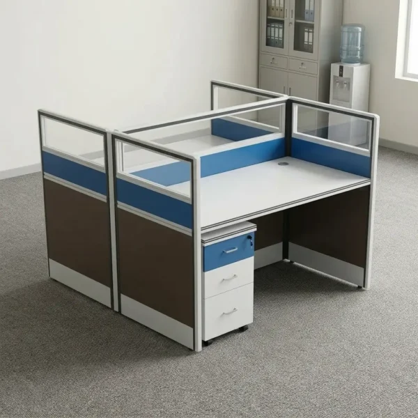 Two seater office working station featuring a face-to-face cubicle layout with white desktop surfaces, partition walls with brown lower panels, blue accent strips, and top clear glass inserts, complete with an under-desk mobile 3-drawer storage pedestal.