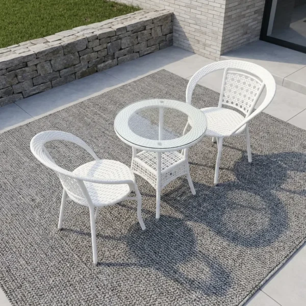 2-seater white outdoor set featuring a durable white woven rattan construction, two matching armchairs with rounded wrap-around backrests and circular patterned mesh details, and a matching round bistro table with a clear glass top and an integrated lower storage shelf.