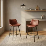 Leather kitchen bar stool featuring warm cognac brown faux leather upholstery with vertical channel tufting, a low-profile ergonomic backrest, and slim matte black metal legs with integrated footrest rungs.