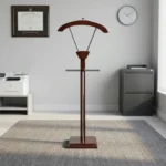 Modern wooden office coat hanger featuring a rich mahogany-finished wood construction, a contoured upper jacket hanger supported by metallic V-struts, a horizontal trouser bar, and a sturdy square base.
