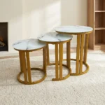 Marble top nest stools featuring a 3-piece set with white faux marble circular tops, distinctive dark veining details, and elegant metallic gold-finished metal frames with open semi-circular base supports.