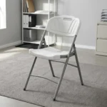 Heavy duty white foldable chair featuring a blow-molded high-density white plastic seat and backrest with a decorative fan motif and built-in carrying handle, supported by a sturdy powder-coated grey steel folding frame with cross-bracing and non-marring foot caps.