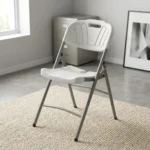 Heavy duty white foldable chair featuring a blow-molded high-density white plastic seat and backrest with a decorative fan motif and built-in carrying handle, supported by a sturdy powder-coated grey steel folding frame with cross-bracing and non-marring foot caps.