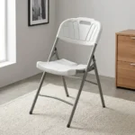 Heavy duty white foldable chair featuring a blow-molded high-density white plastic seat and backrest with a decorative fan motif and built-in carrying handle, supported by a sturdy powder-coated grey steel folding frame with cross-bracing and non-marring foot caps.