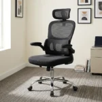 Ergonomic chair with flip armrests featuring a breathable black mesh backrest, an adjustable mesh headrest, integrated lower lumbar support cushion, padded fabric seat, 90-degree flip-up padded armrests, height adjustment lever, and a chrome five-star swivel base with caster wheels.