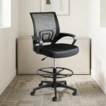 Black ergonomic cashier chair featuring a breathable black mesh backrest with built-in lumbar support, a padded fabric seat cushion, curved fixed armrests, height adjustment lever, an adjustable circular chrome foot ring, and a five-star nylon swivel base with caster wheels.
