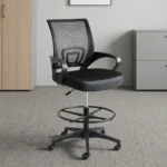 Black ergonomic cashier chair featuring a breathable black mesh backrest with built-in lumbar support, a padded fabric seat cushion, curved fixed armrests, height adjustment lever, an adjustable circular chrome foot ring, and a five-star nylon swivel base with caster wheels.