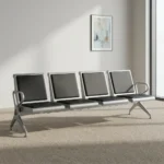 4-seater airport bench featuring four contoured seats with black padded faux leather cushions, silver powder-coated steel frames, curved metallic end armrests, and a heavy-duty beam structure supported by angled metal legs.