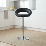 Leather swivel barstool featuring a rounded cutout backrest upholstered in smooth black faux leather, an adjustable gas-lift hydraulic pedestal base in polished chrome, an integrated semi-circular footrest, and a sturdy round trumpet base.