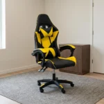 Ergonomic yellow gaming chair featuring high-density black and vibrant yellow faux leather upholstery with a geometric star/X pattern, a high-back racecar-style design, removable headrest cushion and lumbar pillow, padded link armrests, pneumatic tilt/height control levers, and a five-star nylon swivel base with color-accented caster wheels.