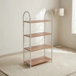 Free standing shoe rack featuring four light wood-grain open shelves, a white powder-coated tubular steel frame with arched side handles, wire side guardrails, and rear X-brace cross-support.