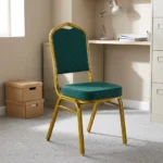 Stackable green conference chair featuring diamond-patterned emerald green upholstered fabric with subtle white dot accents, a cushioned crown-back seat and backrest, top integrated handle grip, and a sturdy metallic gold-painted steel frame with protective floor glides.