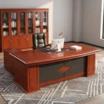 160cm executive office table featuring a rich mahogany wood finish, integrated black leatherette writing inlay, built-in cable management ports, decorative front modesty panel with geometric dark charcoal inlay and center diamond motif, and an L-shaped side return credenza with lockable storage drawers and open shelving.