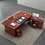 160cm executive office table featuring a rich mahogany wood finish, integrated black leatherette writing inlay, built-in cable management ports, decorative front modesty panel with geometric dark charcoal inlay and center diamond motif, and an L-shaped side return credenza with lockable storage drawers and open shelving.