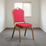 Stackable red conference chair featuring diamond-patterned bright red upholstered fabric with subtle white dot accents, a cushioned crown-back seat and backrest, top integrated handle grip, and a sturdy metallic gold-painted steel frame with non-marring floor glides.