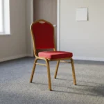 Stackable red conference chair featuring diamond-patterned bright red upholstered fabric with subtle white dot accents, a cushioned crown-back seat and backrest, top integrated handle grip, and a sturdy metallic gold-painted steel frame with non-marring floor glides.