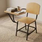 Wooden student study chair featuring light natural oak plywood seat and backrest panels, an attached right-hand tablet writing desk with rounded corners, a tubular black metal frame, and an under-seat wire mesh book basket.