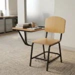 Wooden student study chair featuring light natural oak plywood seat and backrest panels, an attached right-hand tablet writing desk with rounded corners, a tubular black metal frame, and an under-seat wire mesh book basket.
