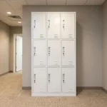 Lockable 9-door steel locker cabinet featuring a durable white powder-coated metal frame, nine individual key-lockable compartments arranged in a 3x3 grid, embedded vertical pull handles, card/label slot holders, and bottom ventilation louvers on each door for airflow.