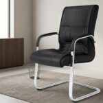 Black leather visitor seat featuring supple black leatherette upholstery with stitched paneling and plush padding, fixed armrests with black protective pads, and a polished chrome-finished cantilever sled base frame.