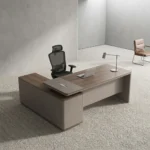Managerial 1.4m office desk featuring a modern two-tone light walnut and taupe grey finish, an L-shaped layout with an integrated side return cabinet, an elevated desktop shelf with built-in cable management ports, and a full-length modesty panel.