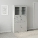 Steel cabinet with safe featuring a powder-coated light grey finish, a top double-door glass display cabinet with key lock, a middle section with three drawers alongside a locked safe compartment, and a bottom double steel-door storage locker with key lock.