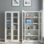 Full glass office file cabinet featuring a clean white powder-coated steel frame, full-length double tempered glass doors with recessed handles and a key lock, and four spacious interior shelves providing five tiers of visible storage.