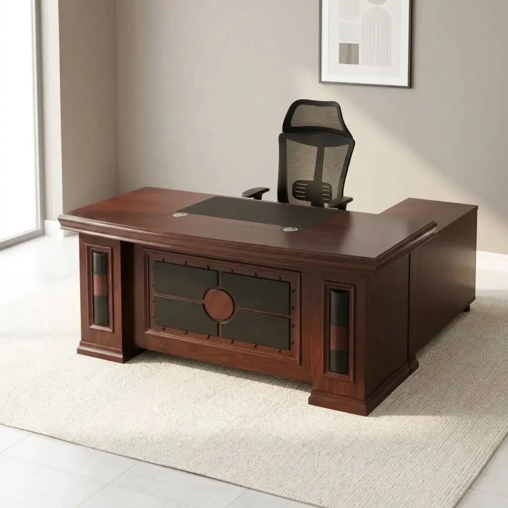 Mahogany 1.6m executive desk featuring a rich wood veneer finish with bevelled edge detailing, an inset black leatherette writing pad, dual desktop cable management grommets, an ornate decorative front modesty panel with black leatherette inlay and circular wood accents, and thick pedestal leg supports.