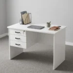 1.0m white home office table featuring a clean matte white laminate desktop, a circular cable management grommet, an integrated three-drawer fixed pedestal with black horizontal pull handles and a top-drawer key lock mechanism, a full-length white modesty panel, and sturdy engineered wood side panel legs.
