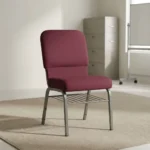 Fabric stackable church chair featuring plush burgundy fabric upholstery with a padded rectangular backrest and waterfall seat design, an armless ergonomic profile, an under-seat metal wire book rack, and a durable silver powder-coated steel frame with protective floor glides.
