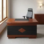 1.2m classic executive desk featuring a rich mahogany wood-veneer finish, a curved-front main desk surface with an inset black leatherette writing pad, dual circular cable management grommets, a front modesty panel detailed with black leatherette panels and a central diamond wood inlay, and a solid wooden plinth base.