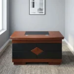 1.2m classic executive desk featuring a rich mahogany wood-veneer finish, a curved-front main desk surface with an inset black leatherette writing pad, dual circular cable management grommets, a front modesty panel detailed with black leatherette panels and a central diamond wood inlay, and a solid wooden plinth base.