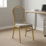 Comfortable armless fabric conference chair featuring patterned beige fabric upholstery over a thick padded seat cushion and backrest, an armless stackable crown-back frame design with an integrated top hand-hold handle, and a durable gold powder-coated square steel four-legged base.