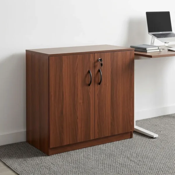 Wooden executive office cupboard featuring a rich walnut wood-grain laminate finish, dual lockable wooden hinged doors with curved black D-pull handles, internal storage shelves, and a solid full-width plinth base.